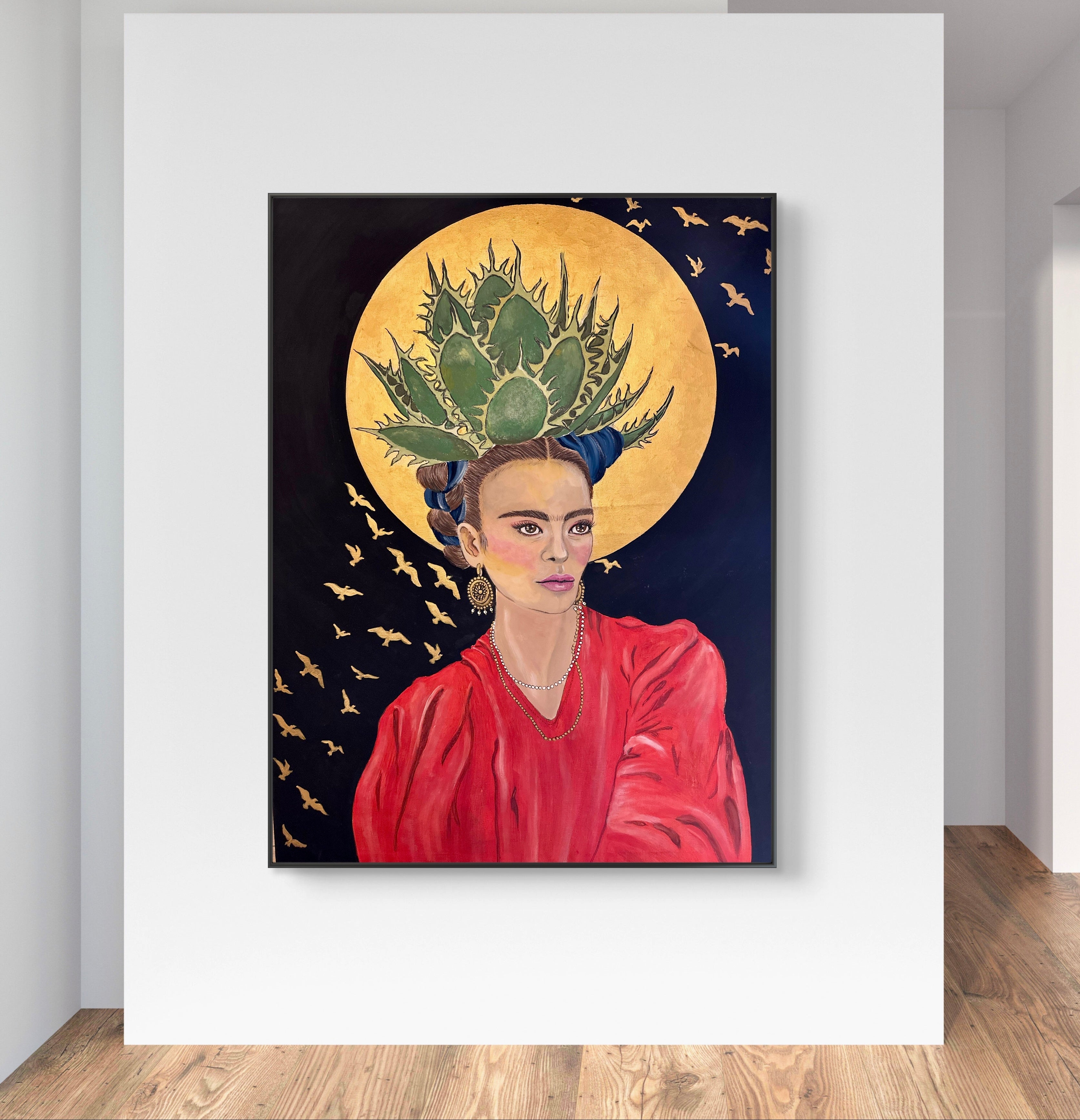 Framed artwork of a woman with a green headpiece and red garment on a white wall.